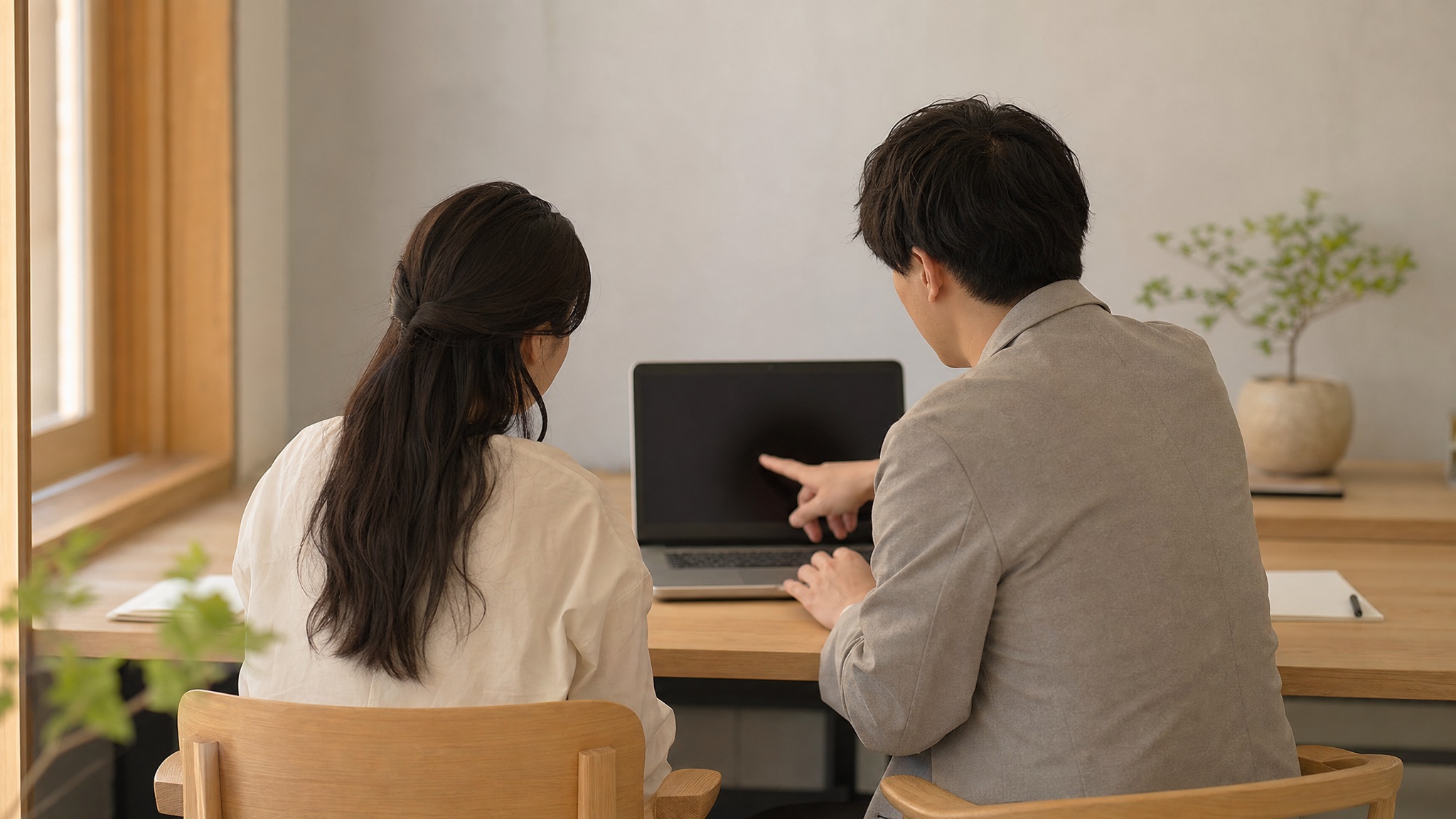 支援員と利用者がノートパソコンの画面を一緒に見ている様子